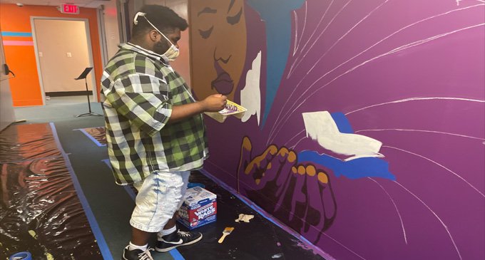 Local artist Leo Rucker and art students create murals to  brighten school hallways